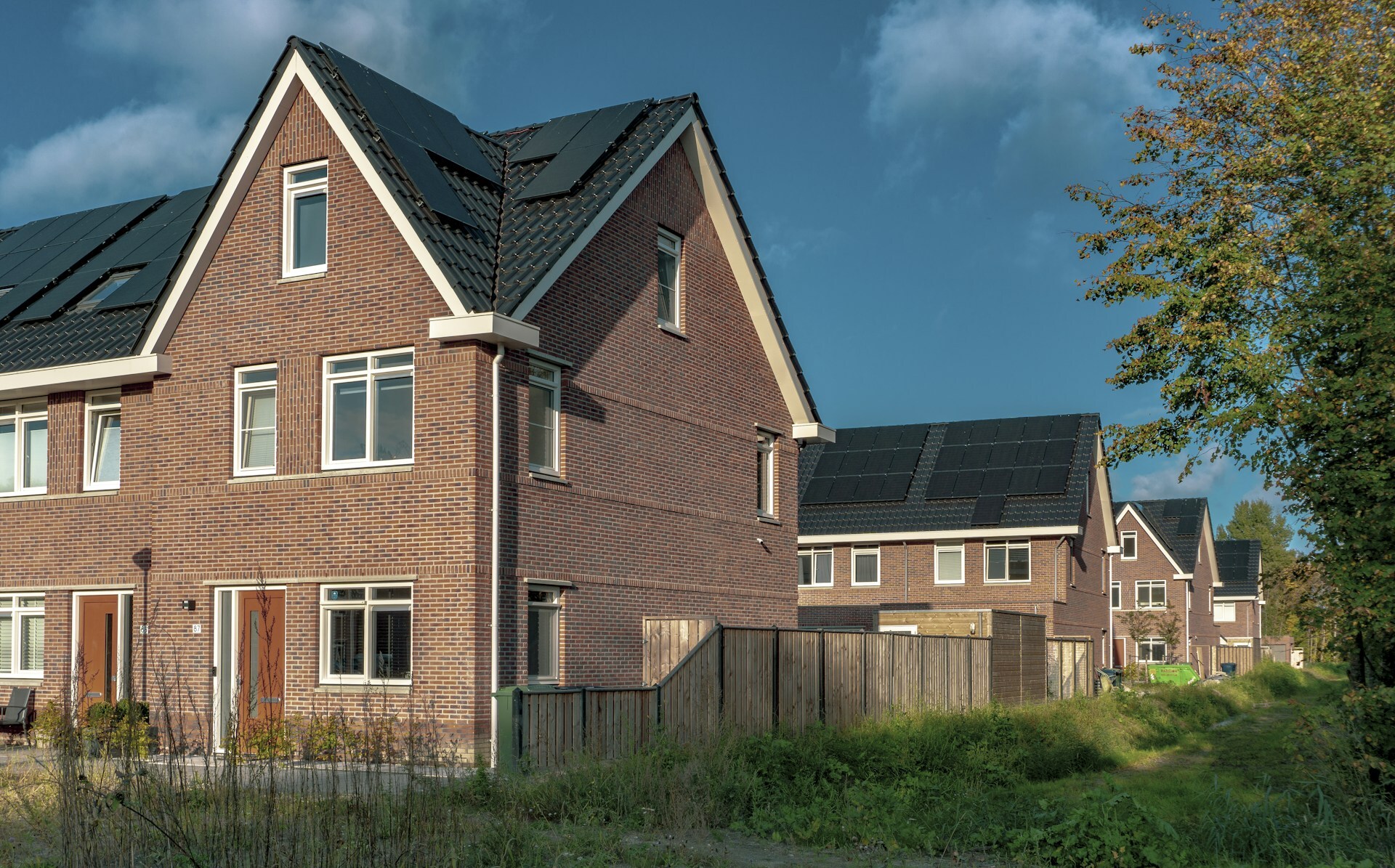 Nieuwbouwwoningen met zwarte zonnepanelen op het dak